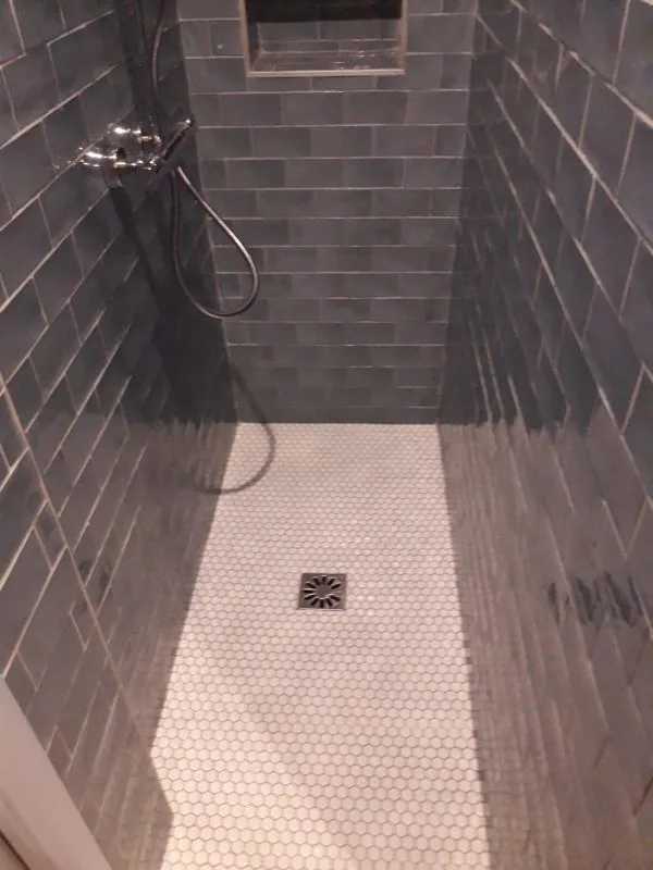 Douche carrelée gris foncé avec receveur à mosaïque