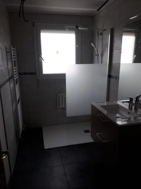Salle de bains avec douche, paroi en verre dépoli et meuble vasque noir