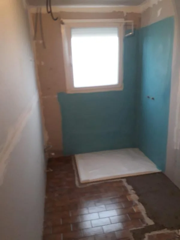 Salle de bains en travaux avec cloison hydrofuge bleue