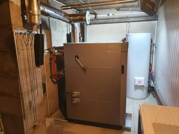 Chaudière bois brune et ballon d’eau chaude dans une chaufferie