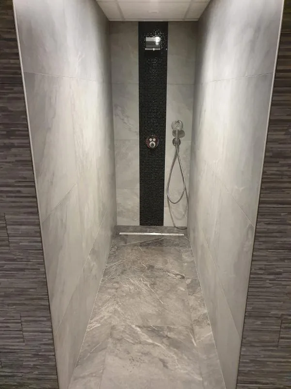 Douche carrelée avec colonne de douche noire